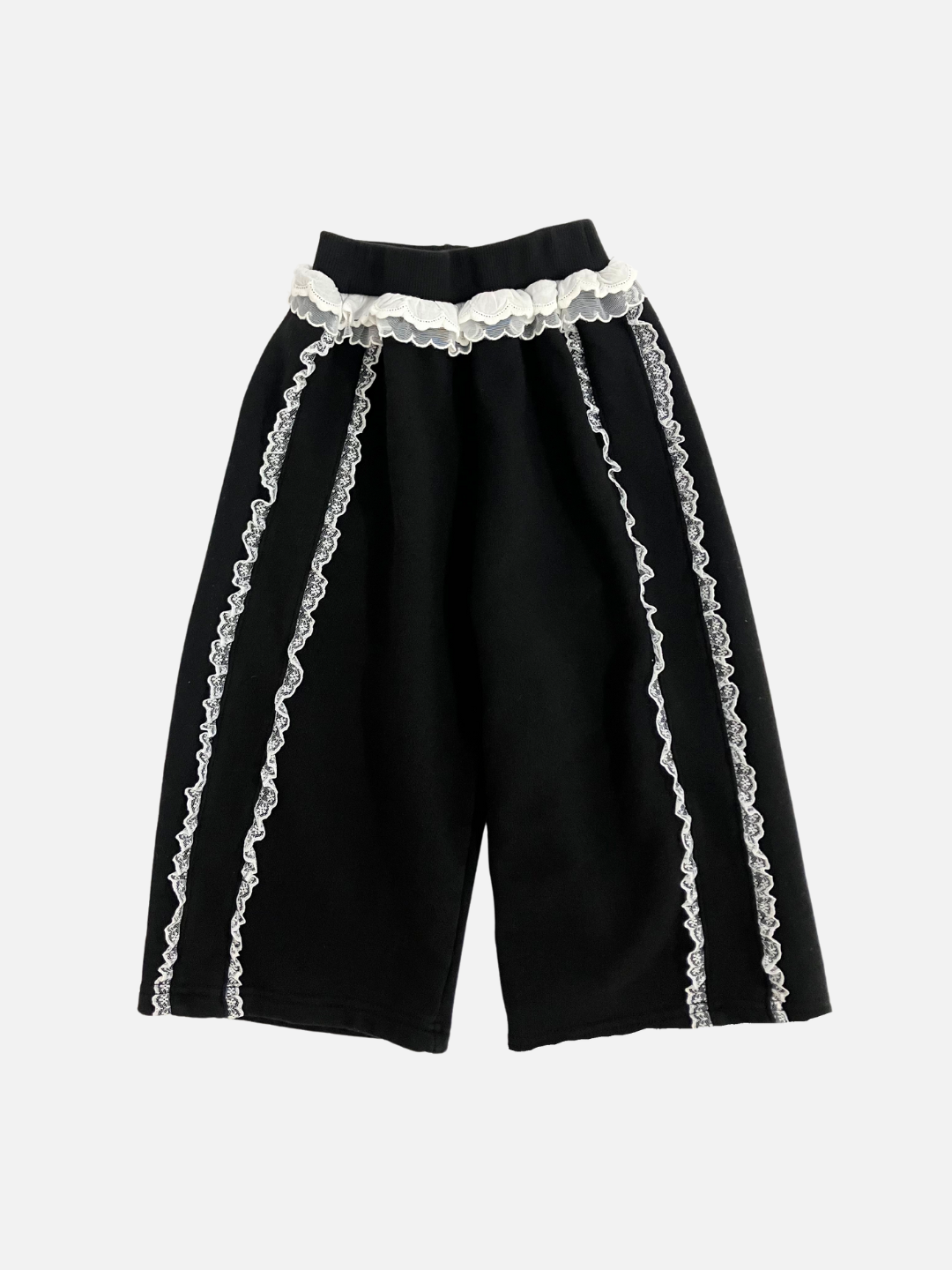 Front view of kid's Relay pants in black with  white ruffles at the waist and down both legs