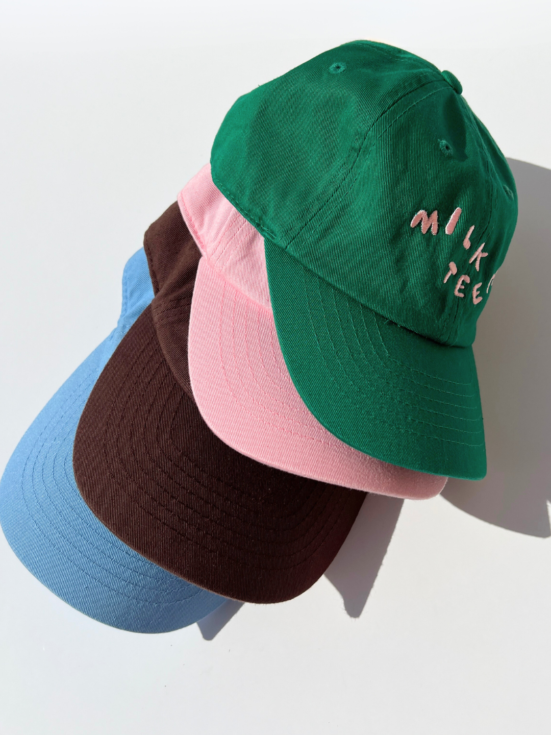 Kelly Green | A stack of Milk Teeth embroidery caps