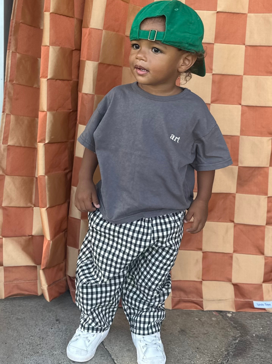 Second image of Front view of kids black and off-white gingham check pants.