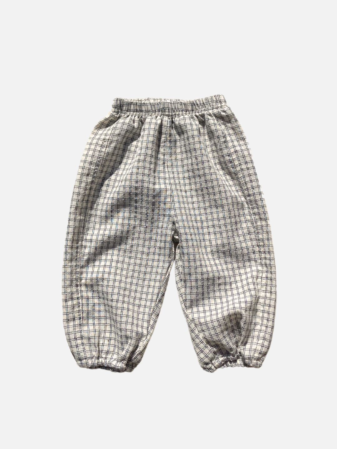 Front view of the kids' Grid Check Pull on Pant. Cream fabric with light black grid print.