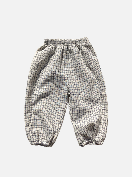 Image of Front view of the kids' Grid Check Pull on Pant. Cream fabric with light black grid print.