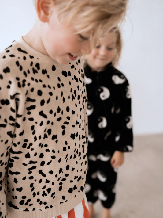 Second image of The DALMATIAN TERRY SWEATSHIRT, a beige long-sleeve sweatshirt featuring a black abstract spotted pattern, is perfect for babies and laid flat on a white background. Check out this piece and other new arrivals when you shop all clothing.