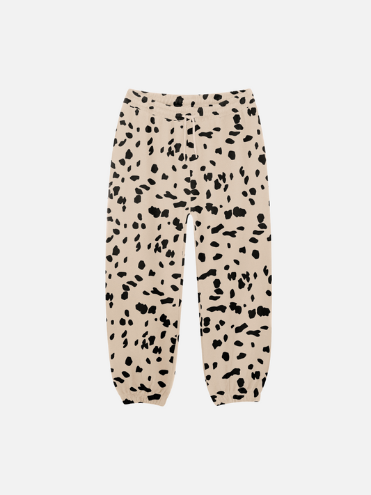 Image of These new arrivals, the DALMATIAN TERRY JOGGER, feature beige pants with a black abstract spot pattern and elastic cuffs, perfect for stylish baby clothing.