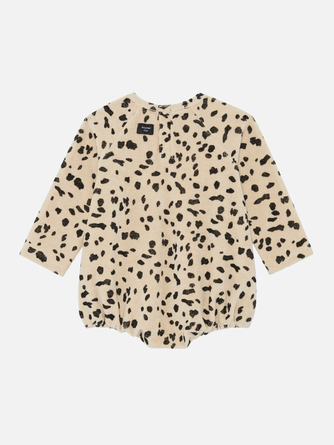 Our charming new arrival, the DALMATIAN TERRY BODYSUIT, is a beige long-sleeve baby romper with black spots, laid flat and viewed from the back.