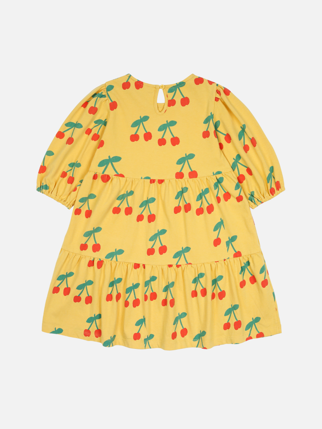 The CHERRY RUFFLE DRESS is a yellow children's dress with a cherry print, featuring short sleeves and a tiered skirt.