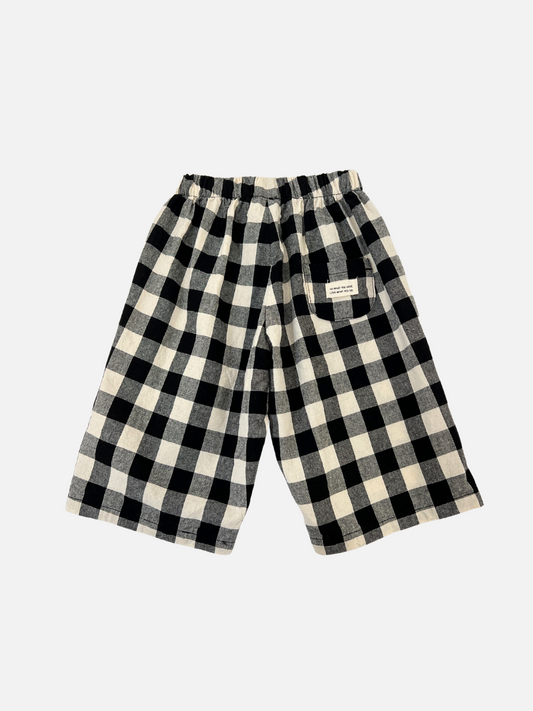 Second image of BIG GINGHAM BABY PANTS, featuring a black and white checkered design with an elastic waistband, are essential merchandise displayed on a plain white background.