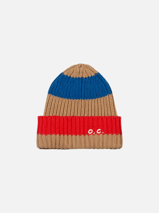 Image of The STRIPED BEANIE is a rib knit hat made from a cotton wool blend, featuring tan, blue, and red stripes with "o.c." embroidered in white on the red fold-over cuff.