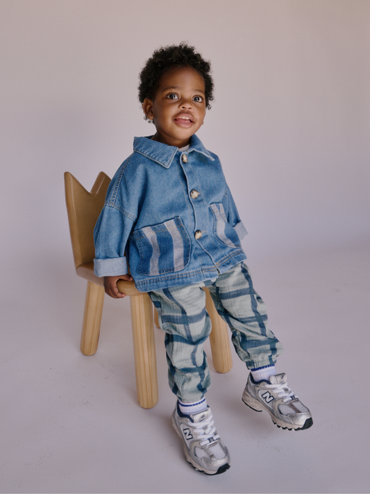 Second image of Medium Wash | Introducing the STRIPE POCKET CHORE COAT, a medium wash cotton denim jacket with buttons and two large front pockets adorned with vertical striped patterns, reminiscent of the practical style of a chore coat.