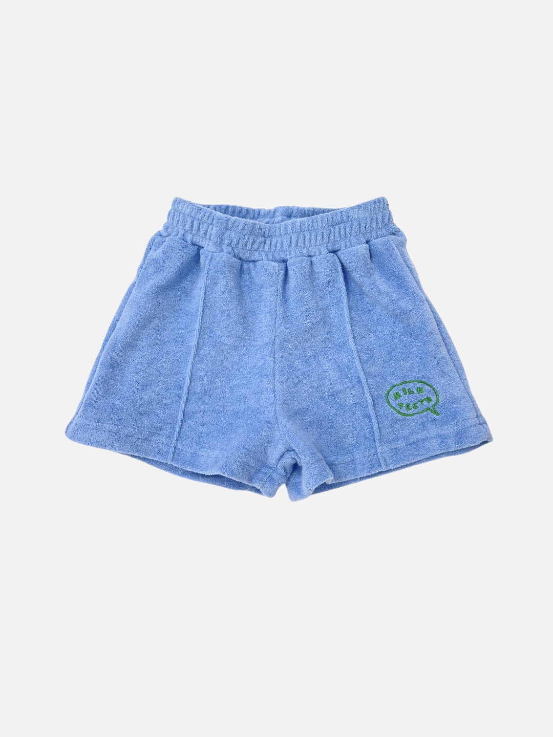 EVERYDAY TERRY SHORTS in blue cotton terry with an elasticated waist and a green embroidered patch on the left leg, shown on a white background.