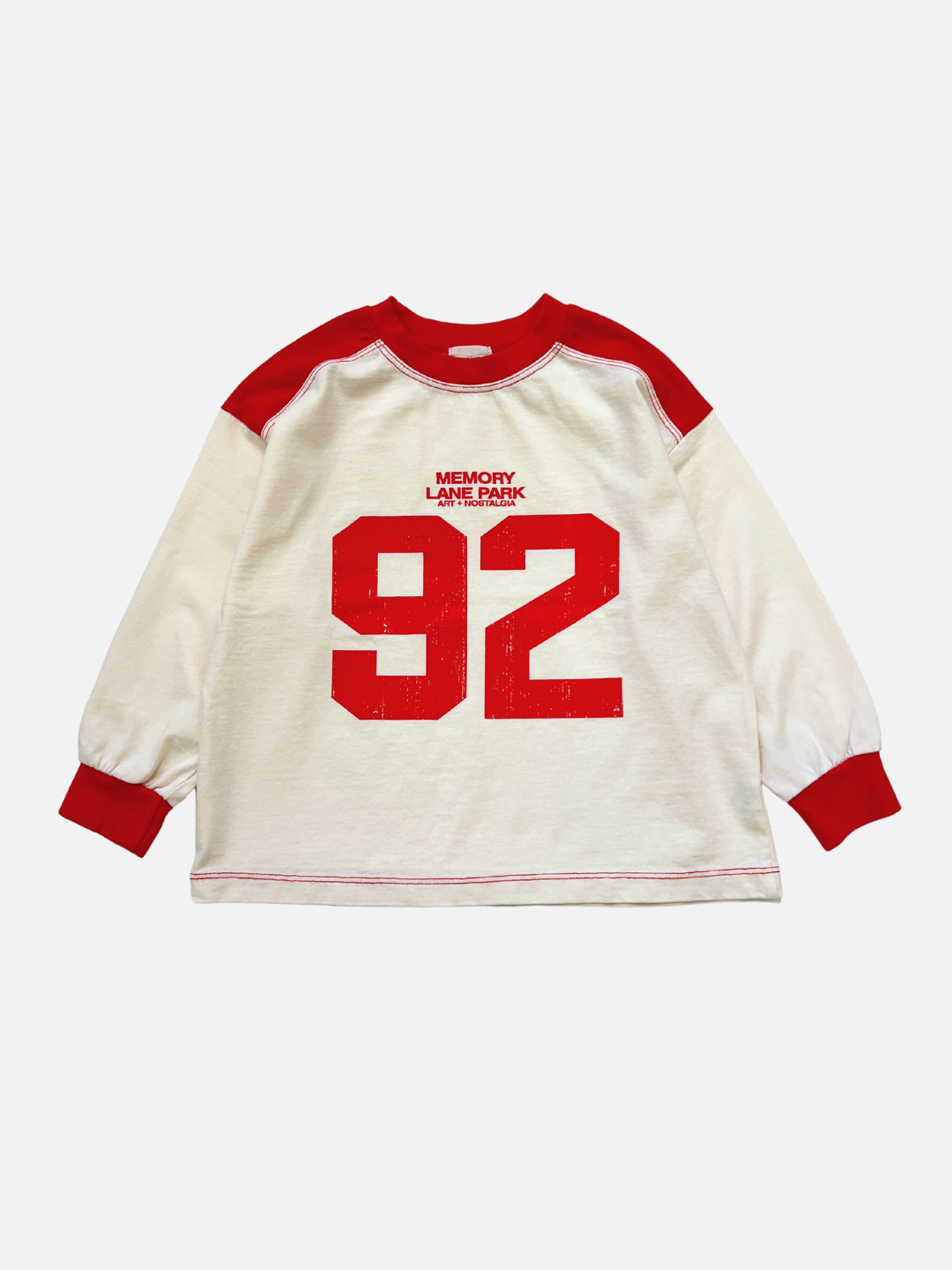 The MEMORY LANE LONGSLEEVE features a vintage sports jersey-inspired design in red/cream, with a red collar and cuffs, cream body, bold red “92” graphic, and “MEMORY LANE PARK” text on the front.
