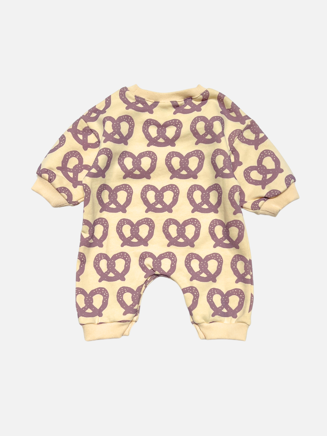 Back view of a baby long-sleeve romper in cream with an all-over purple pretzel print, shown flat against a light gray background.