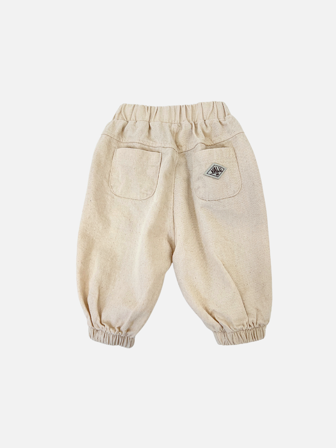 Ecru | Valu Baby introduces the BALLOON JEAN in beige, designed for children with an elastic waistband and jogger-style fit. It features two back pockets and a small patch on the right pocket, perfect for little ones.