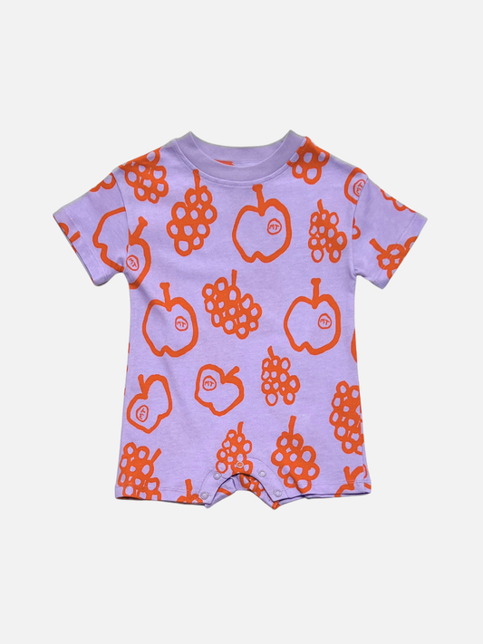 Image of The FRUIT STAND ROMPER is a lavender short-sleeve organic cotton baby outfit with orange apple and grape fruit prints, perfect for summer, shown on a white background.