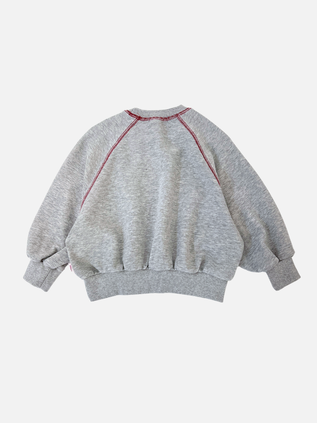 Grey | The VARSITY SWEATSHIRT is a retro-style gray piece from Cantucci Studios, made of brushed cotton with red stitching, featuring raglan sleeves and a loose fit, displayed elegantly from the back against a plain white background.