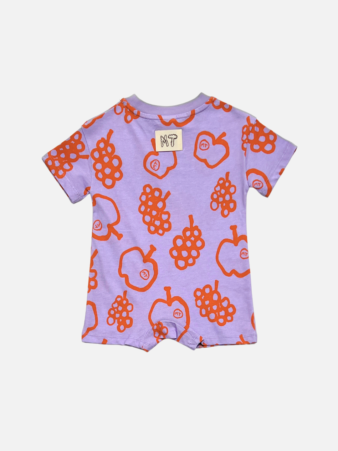 The FRUIT STAND ROMPER is a short-sleeved lavender baby romper with orange, apple, and grape prints, made from organic cotton and finished with a small "MT" patch on the back—ideal for summer wear.
