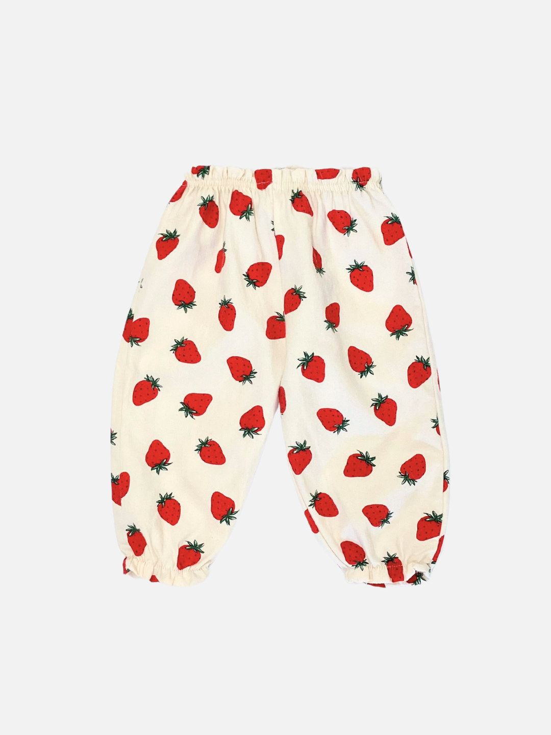 Aosta kids clothing introduces the STRAWBERRY PANTS, featuring a delightful red strawberry print on a white background, crafted from brushed cotton for children. These pants come with an elasticized waist and ankle cuffs.