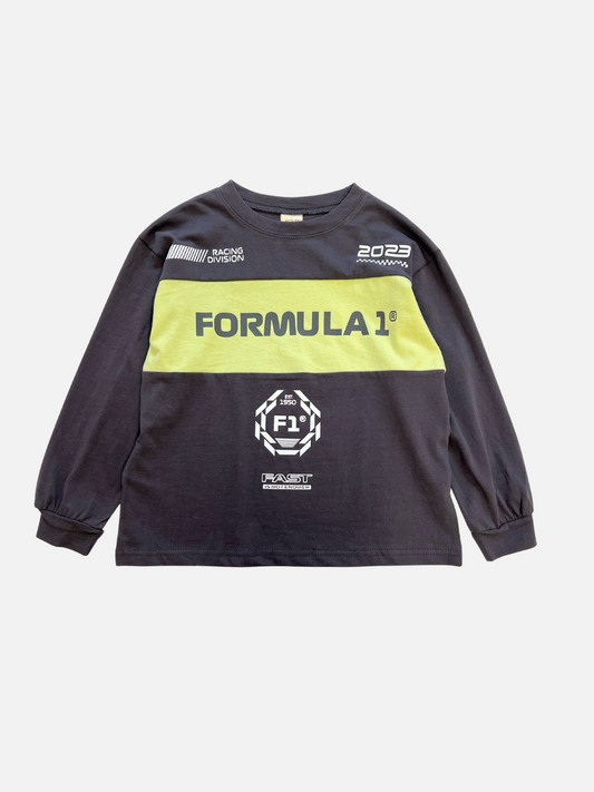 Image of The RACING LONGSLEEVE is a black kids’ crewneck tee with long sleeves, yellow chest stripe, white “FORMULA 1” text, and racing graphics. Made from soft cotton jersey by a top Korean kids' brand.