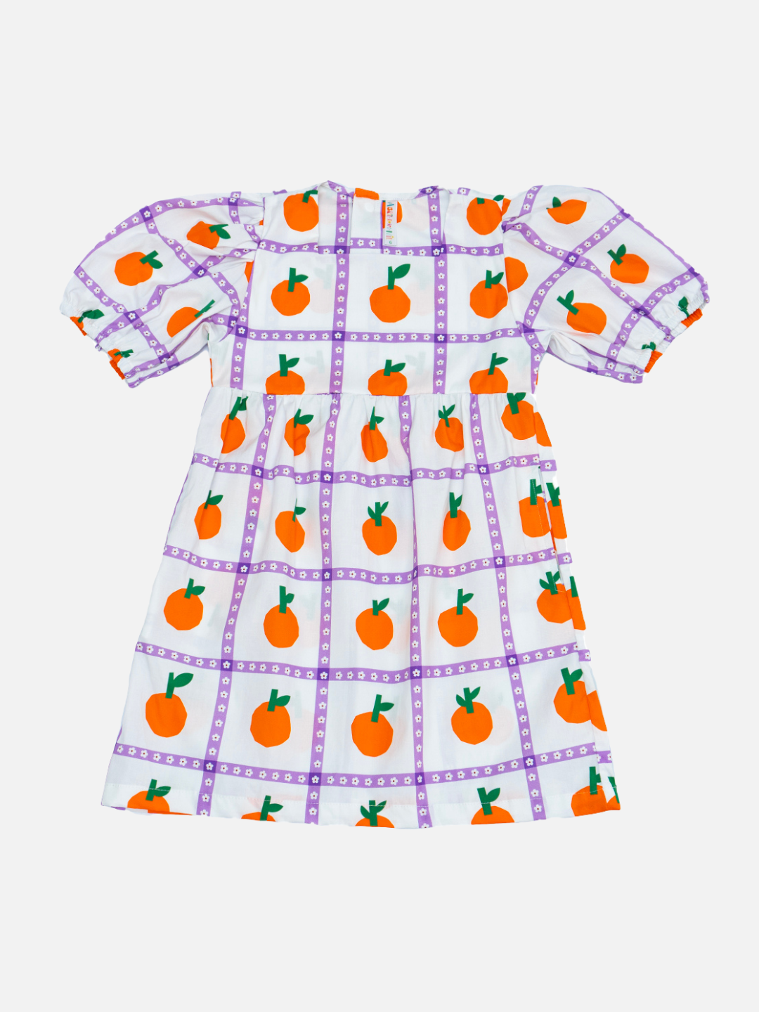 A front view of the kid's Glow dress with an all-over oranges print