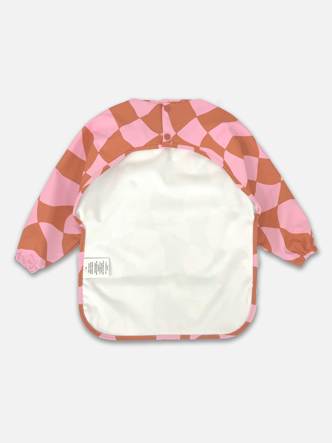 The back view  of the long sleeve light pink and rust wavy checked bib with a back cut out and two buttons for closure.