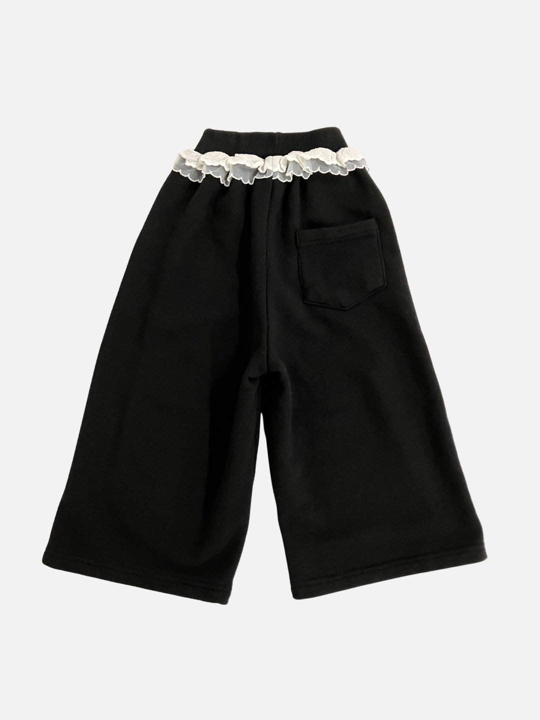 Back view of kid's Relay pants in black with  white ruffles at the waist