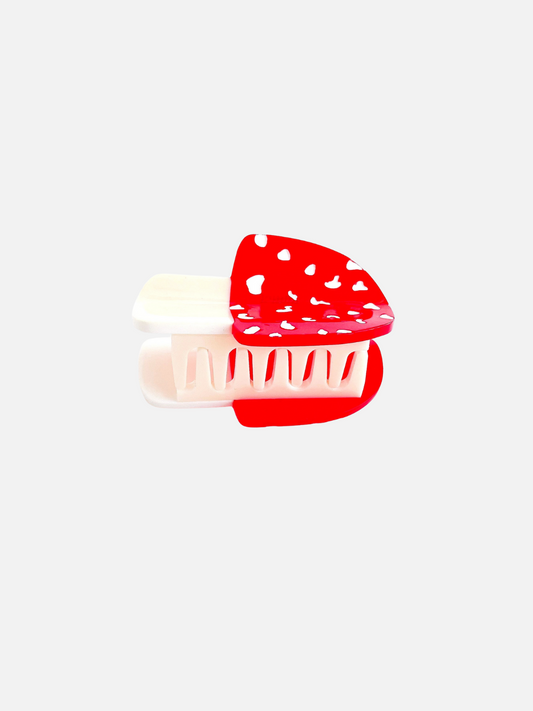 Second image of The MINI MUSHROOM HAIR CLAW features a red and white patterned design, crafted from biodegradable cellulose acetate, set against a plain white background.