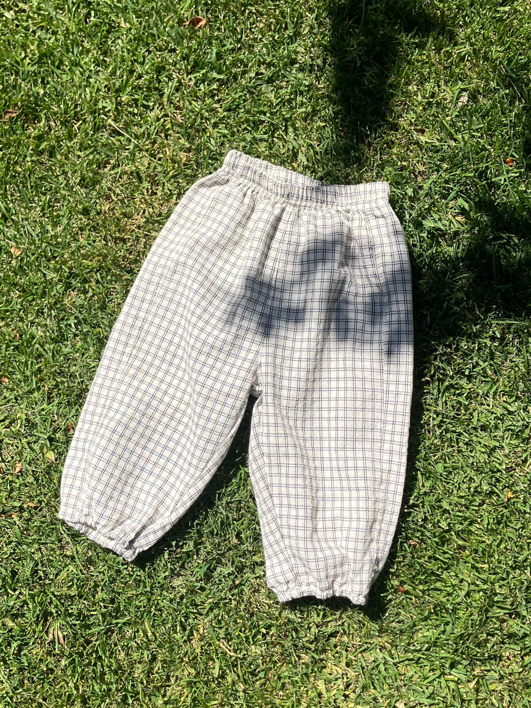Kids' grid check pull-on pant laid flat on the grass