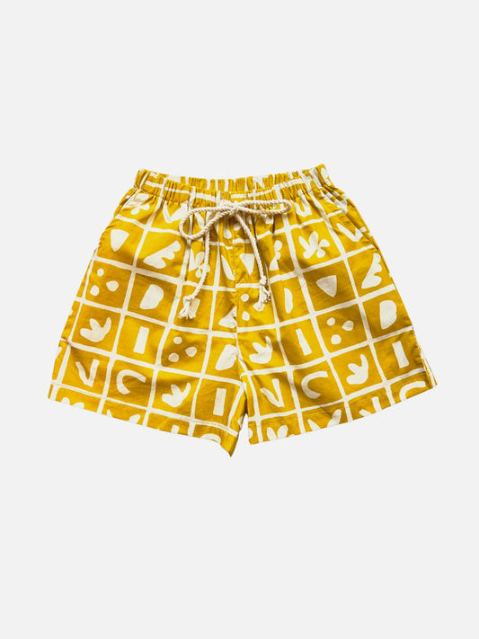 Image of A pair of kids' shorts in mustard yellow overlaid with a grid of different shapes in white