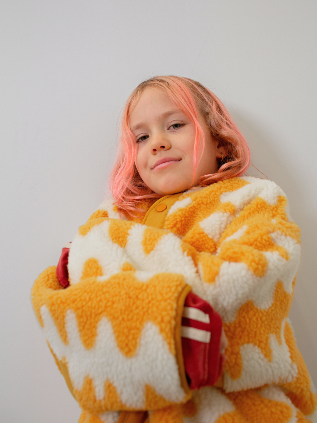 Yellow | Person wearing a yellow and white patterned coat against a plain background