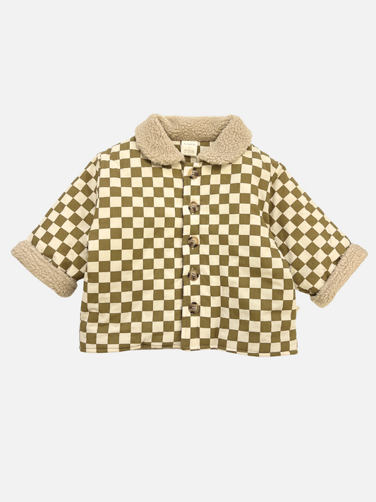 Image of The EMERY COCO CHECKERBOARD COAT is a unisex short-sleeve button-up jacket with a brown and white checkerboard pattern, tan sherpa collar, rolled cuffs, and crafted from cotton for stylish outerwear.