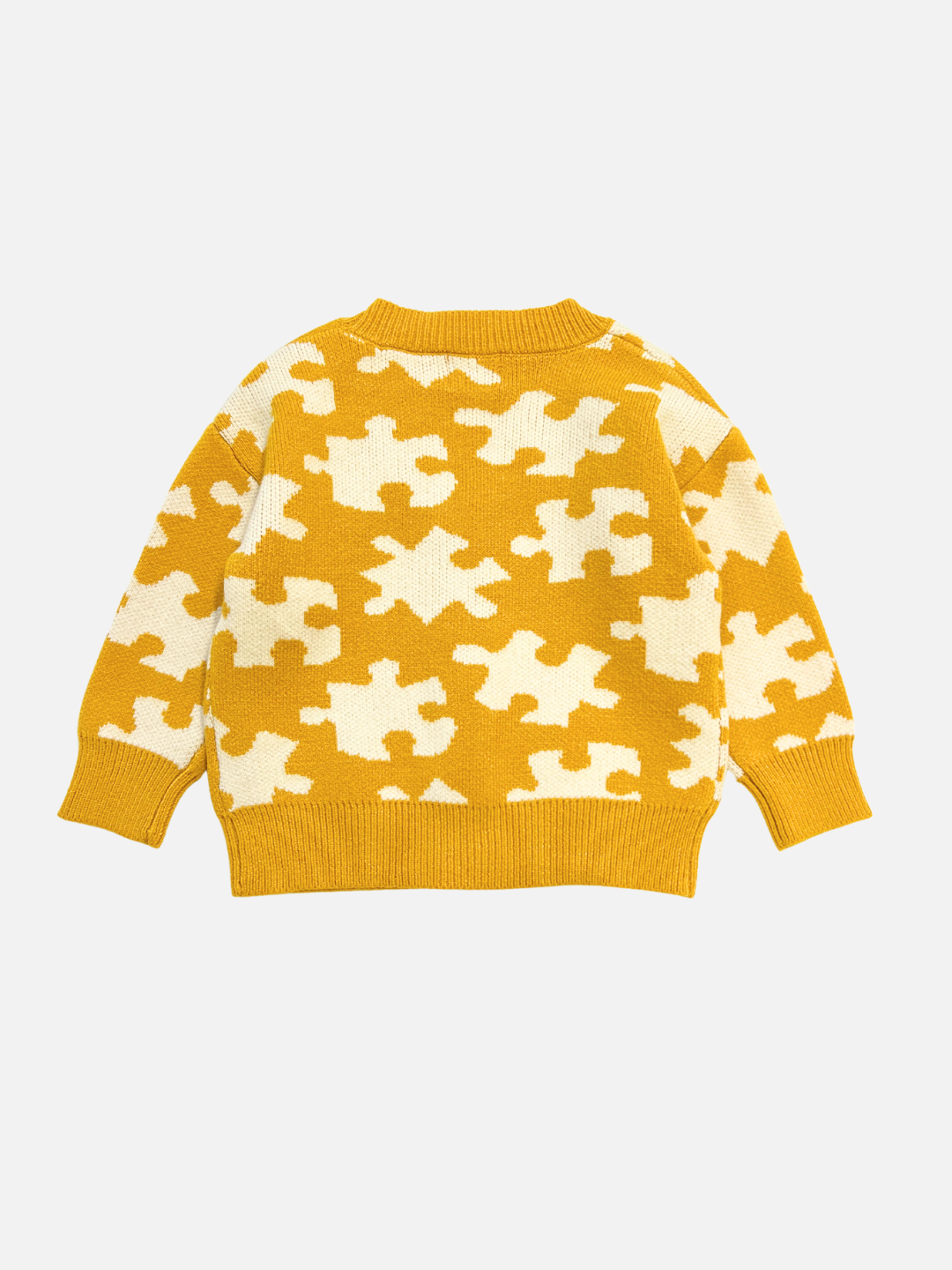 The PUZZLE CARDIGAN is a yellow knit sweater featuring a white puzzle piece pattern, displayed flat on a white background.