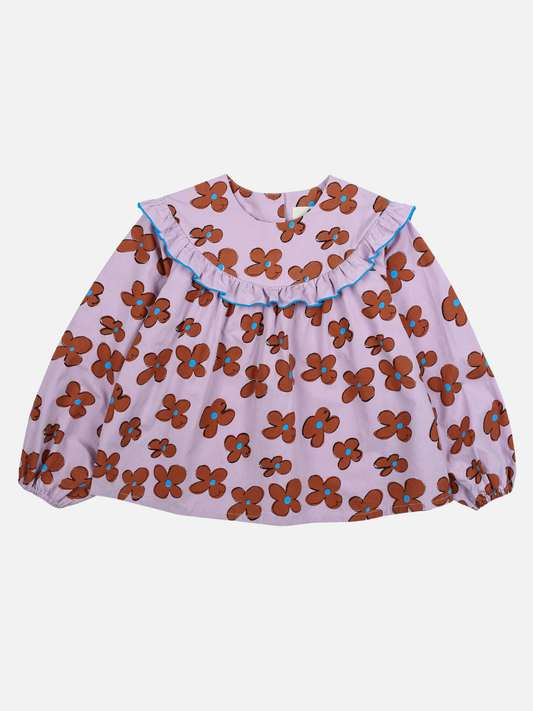 Image of FLOWER FRILL BLOUSE - A long-sleeve children's dress with a purple background and brown floral pattern, featuring a ruffled collar with blue trim. Built for durability according to care instructions.