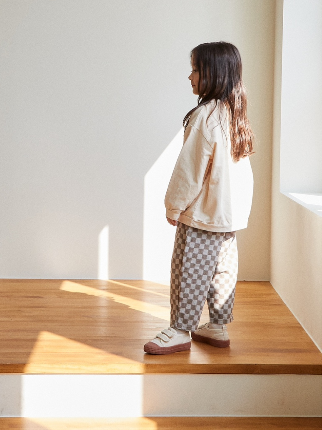 A child wearing chess club pants in stone