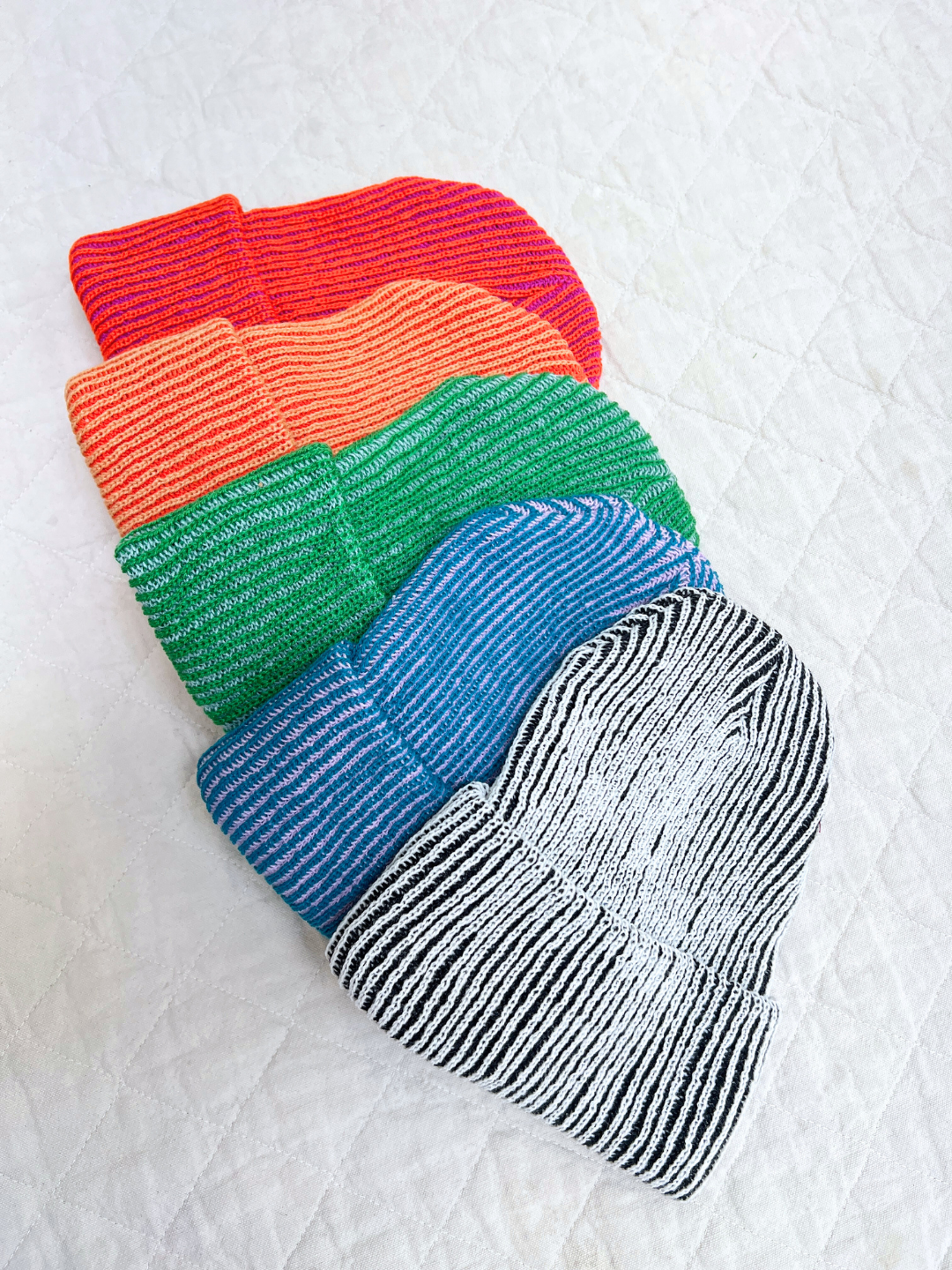 Set of colorful socks stacked on a textured white surface