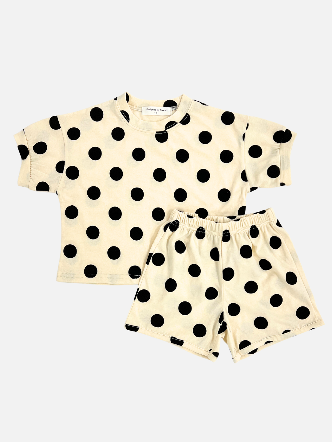  A kids' tee shirt and shorts set in a pattern of black dots on an ecru background