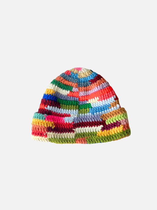 Image of The COLOR WHEEL BEANIE in size 3-6M is a handmade hat with a multicolored patchwork, folded brim, and vibrant stripes—perfect for adding playful style to your winter wardrobe.