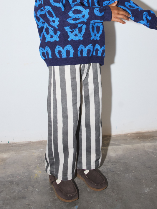 Second image of A pair of wide-leg kids pants featuring bold vertical black and off-white stripes, displayed flat against a light gray background.