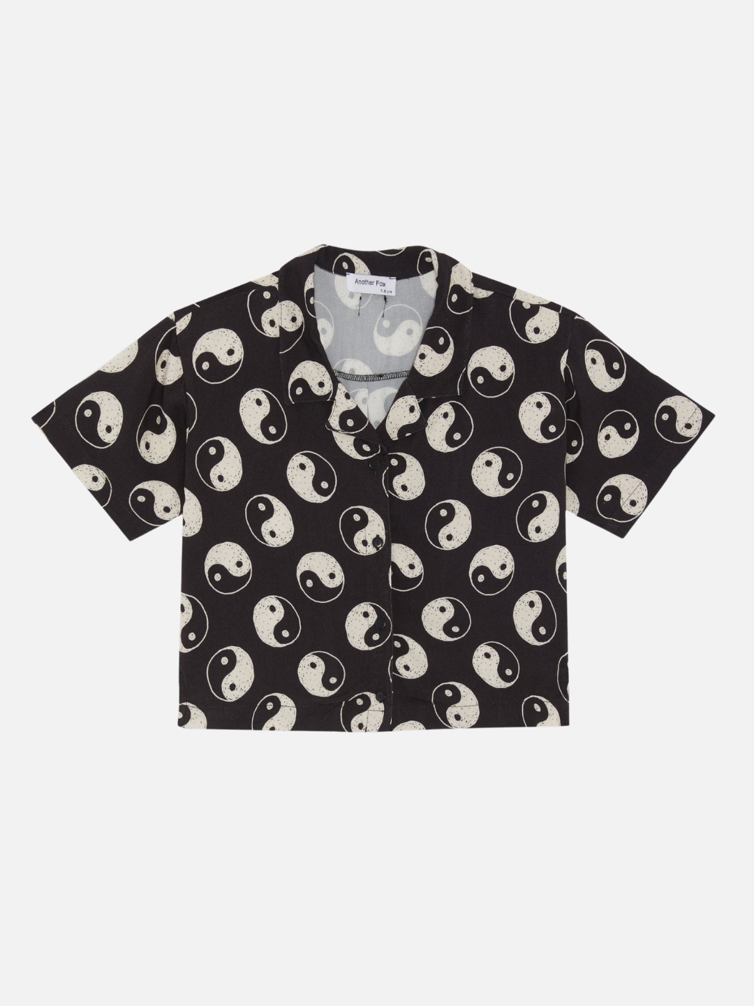 A front view of the black button up shirt with a yin and yang pattern all over.