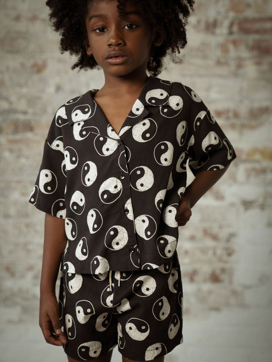 Second image of A front view of the black button up shirt with a yin and yang pattern all over.