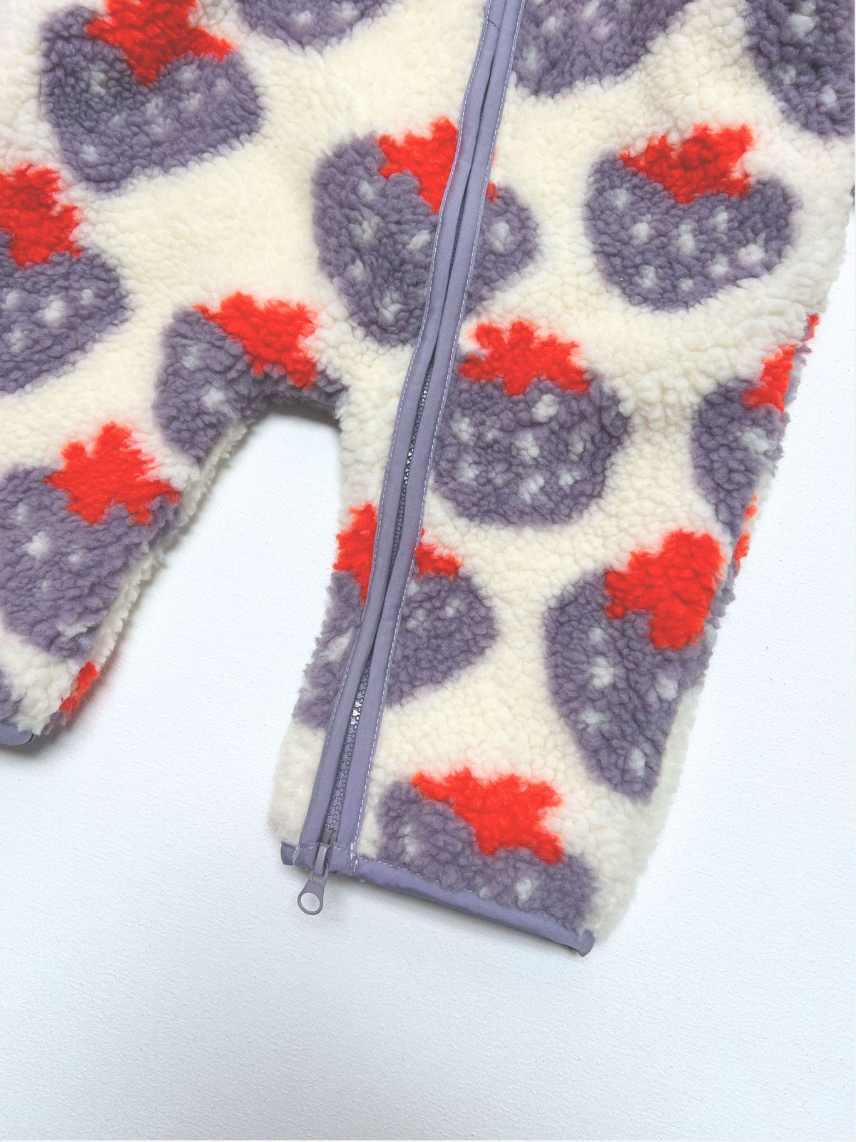 STRAWBERRY SHERPA FLEECE STROLLER SUIT in off-white with a purple zipper and a pattern of purplestrawberries with red tops.