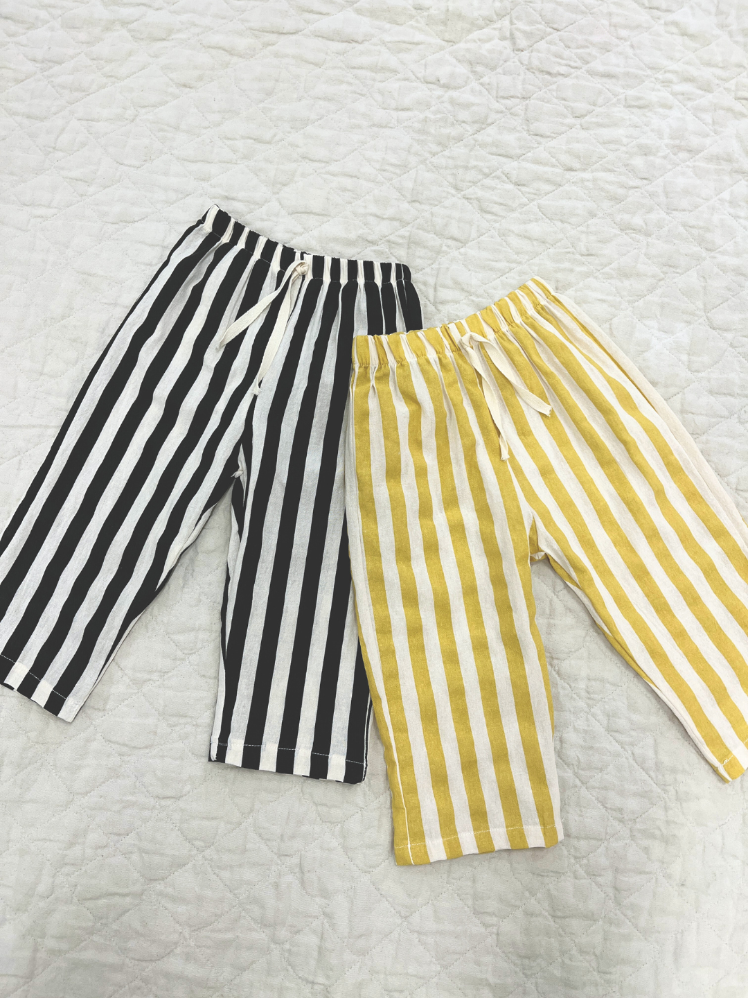 Black & yellow striped pants on a blanket 