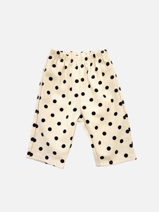 Image of POLKA DOT PANT: Beige children's pants with a relaxed fit, elastic waistband, and black polka dot pattern in soft double-layer cotton, shown on a white background.