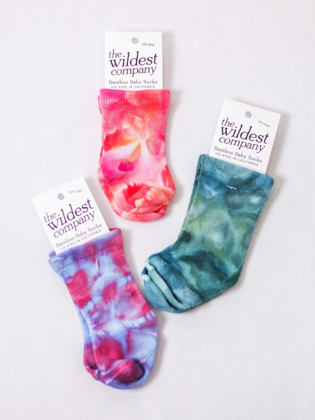 Ultraviolet | Three pairs of Bamboo Baby Socks laid flat highlighting the Wildest Company packaging