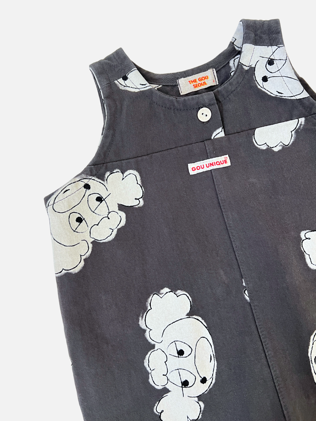 The POODLE OVERALL is a sleeveless dark gray top with button fastening, adorned with cartoon-style cloud patterns. A red label reads "GOU UNIQUE," reminiscent of a playful Korean kids label.