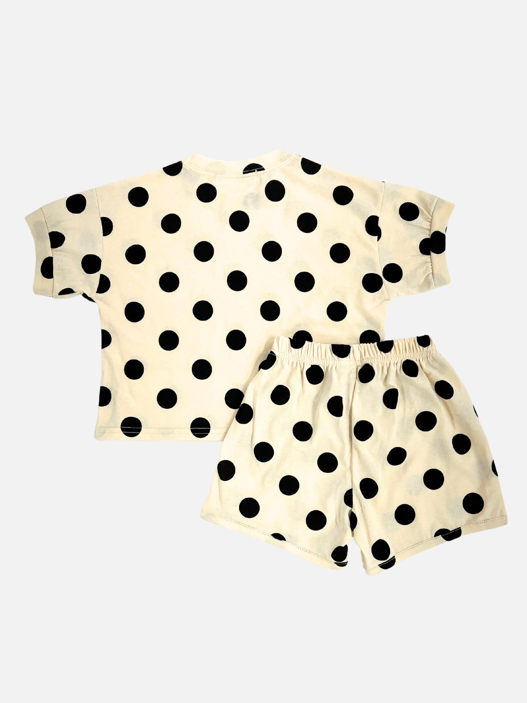 Black |  A kids' tee shirt and shorts set in a pattern of white dots on an ecru background, back view