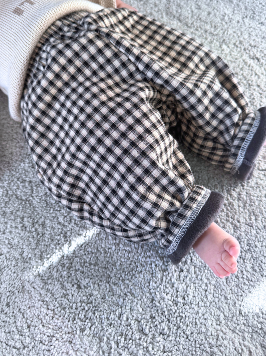 Second image of FLEECE-LINED BABY PANT in a black and white checkered design, featuring an elastic waistband and a cozy polar fleece lining, displayed on a plain white background.