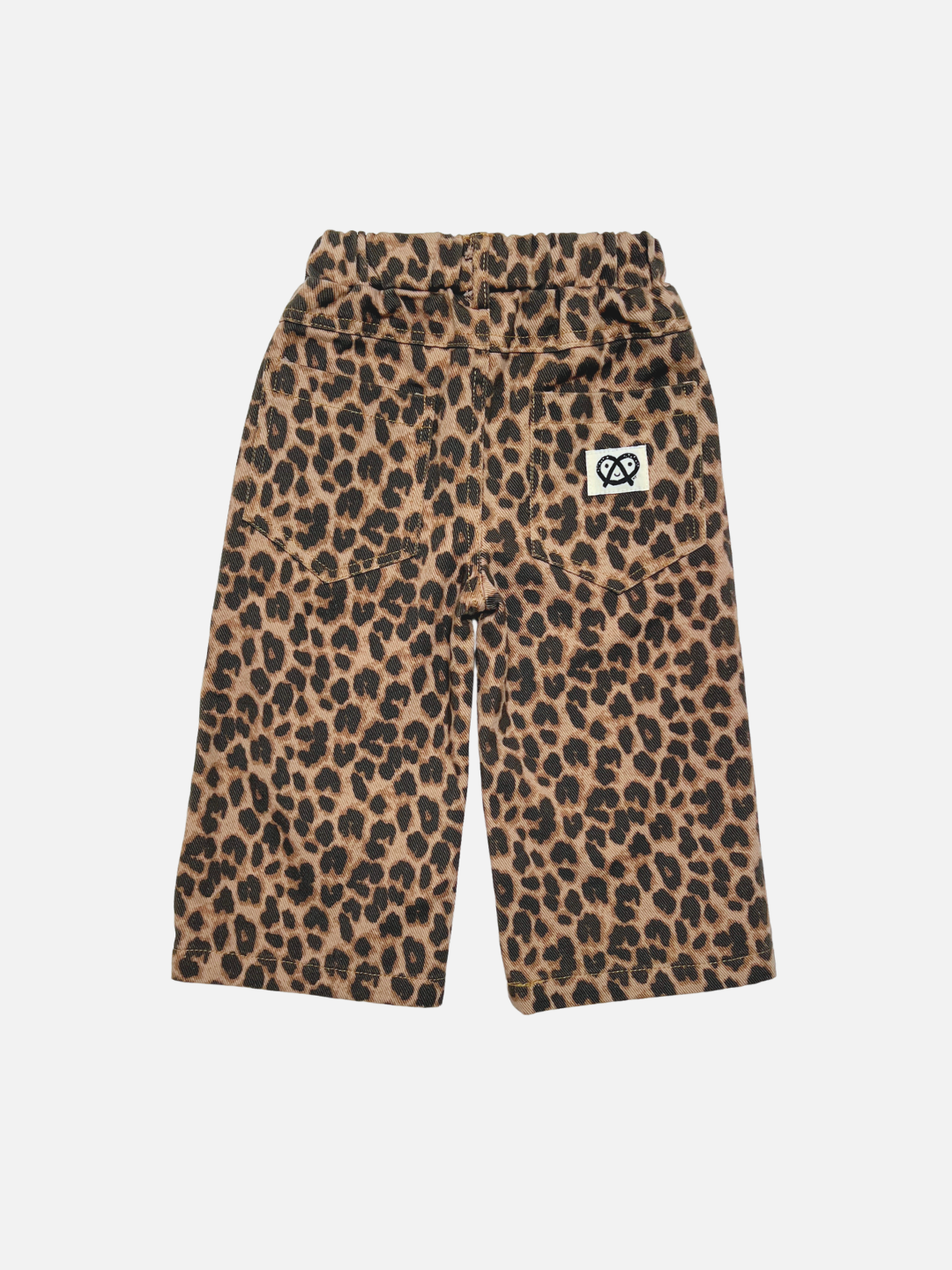 A pair of toddler's wide-leg trouser jeans featuring a brown and black leopard print pattern, an elastic waist, and a small white pretzel logo patch on the left back pocket, displayed against a solid light gray background.