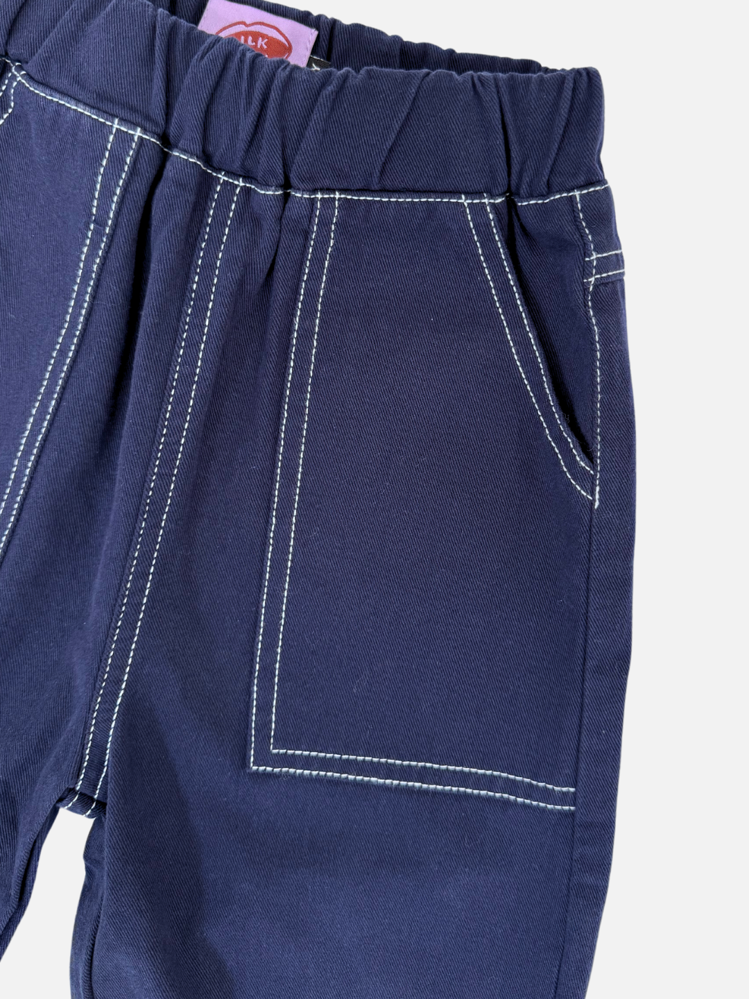 Navy | Close-up of TOPSTITCH TWILL PANTS in dark blue, made from soft cotton twill, with an elastic waistband and white-stitched seams and pockets.