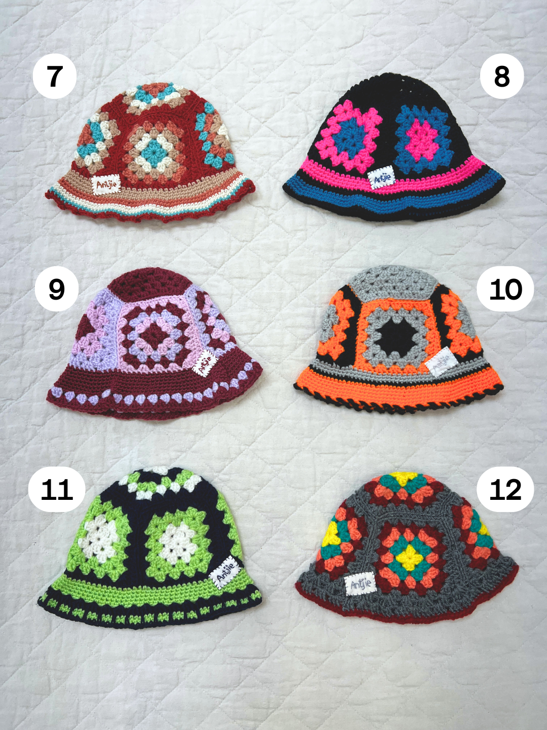 A CROCHETED BUCKET HAT 1-3Y in color #7, featuring vibrant South Africa-inspired granny square patterns, is displayed on a quilted surface.