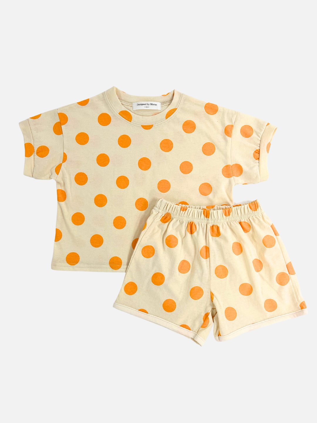 Orange | A kids' tee shirt and shorts set in a pattern of orange dots on an ecru background