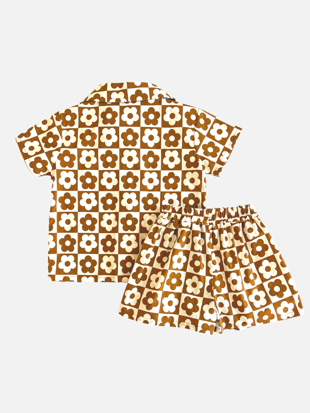 Terracotta | Set of kids' shirt and shorts in a checkerboard pattern of terracotta brown and white flowers, laid on a table, back view